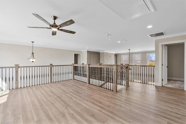 spare room featuring visible vents, attic access, recessed lighting, ornamental molding, and light wood-type flooring