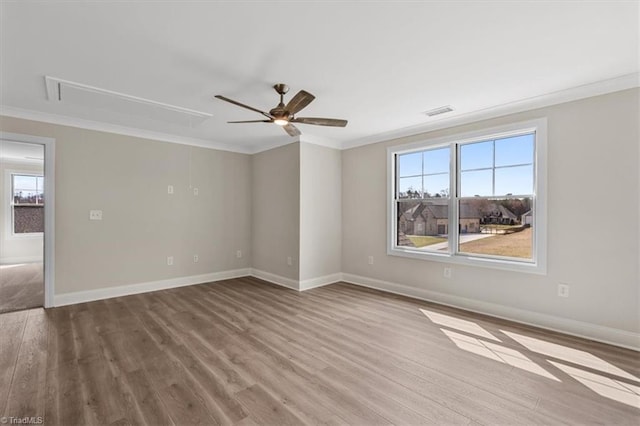 unfurnished room with attic access, wood finished floors, and crown molding