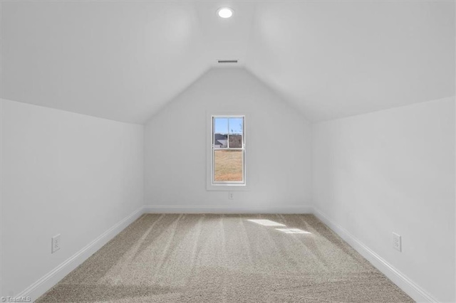 additional living space with baseboards, lofted ceiling, carpet floors, and visible vents