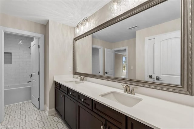 full bath featuring double vanity, bathing tub / shower combination, and a sink