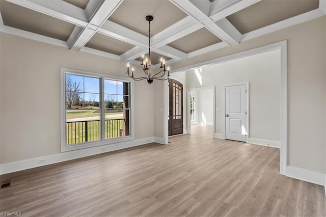 spare room with a notable chandelier, coffered ceiling, light wood-type flooring, and baseboards