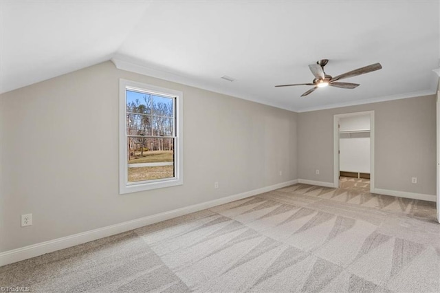 unfurnished bedroom with a spacious closet, baseboards, light colored carpet, lofted ceiling, and a ceiling fan