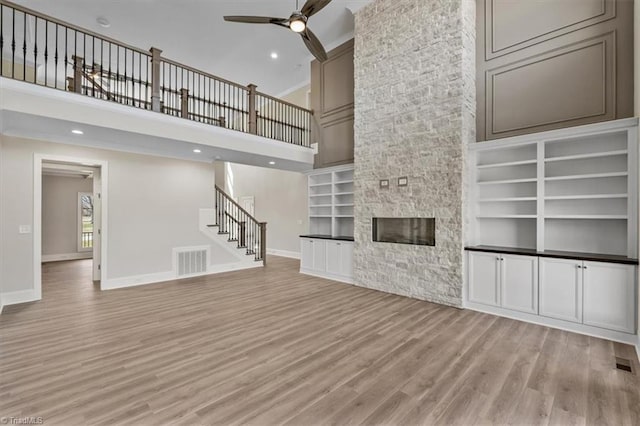 unfurnished living room featuring visible vents, baseboards, light wood-type flooring, and ceiling fan