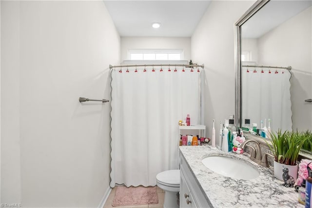 bathroom with tile patterned flooring, vanity, and toilet