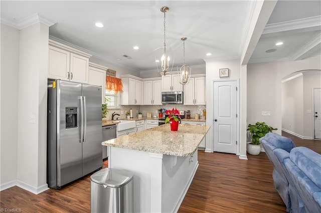 kitchen with stainless steel appliances, decorative light fixtures, a kitchen bar, decorative backsplash, and a kitchen island