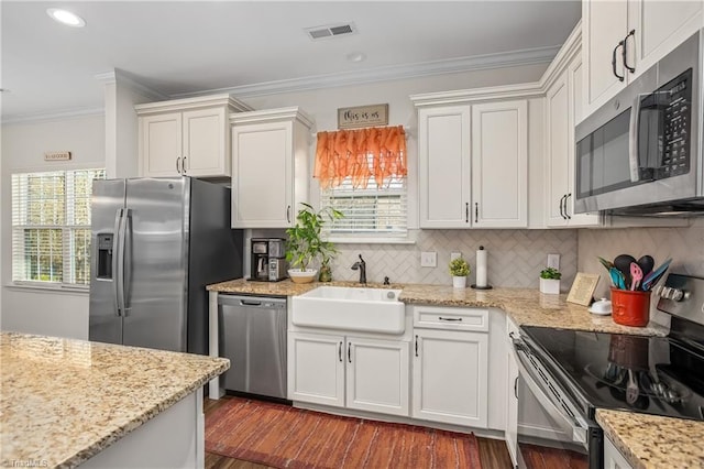 kitchen with white cabinets, appliances with stainless steel finishes, tasteful backsplash, and sink