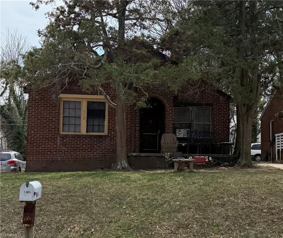 view of front facade featuring brick siding and a front yard