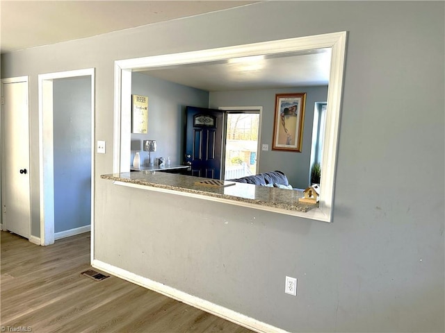 kitchen with visible vents, baseboards, and wood finished floors