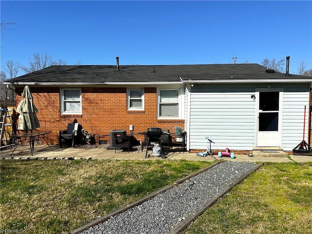 back of house with a lawn and a patio