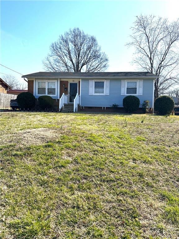 ranch-style house featuring a front yard and fence