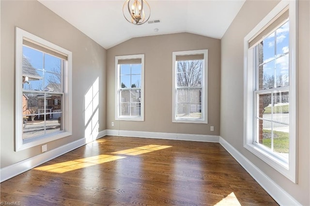 unfurnished dining area with dark wood finished floors, baseboards, a chandelier, and lofted ceiling