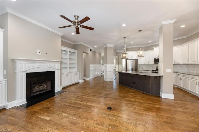 unfurnished living room with a ceiling fan, wood finished floors, and a fireplace with flush hearth