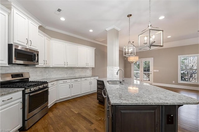 kitchen featuring white cabinetry, a center island with sink, appliances with stainless steel finishes, and pendant lighting