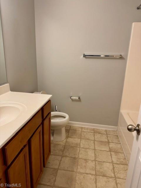 bathroom with vanity, toilet, and a washtub