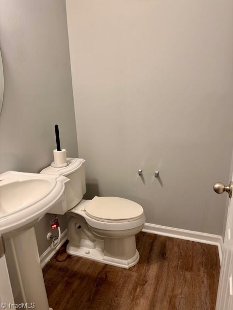 bathroom with hardwood / wood-style flooring, toilet, and sink