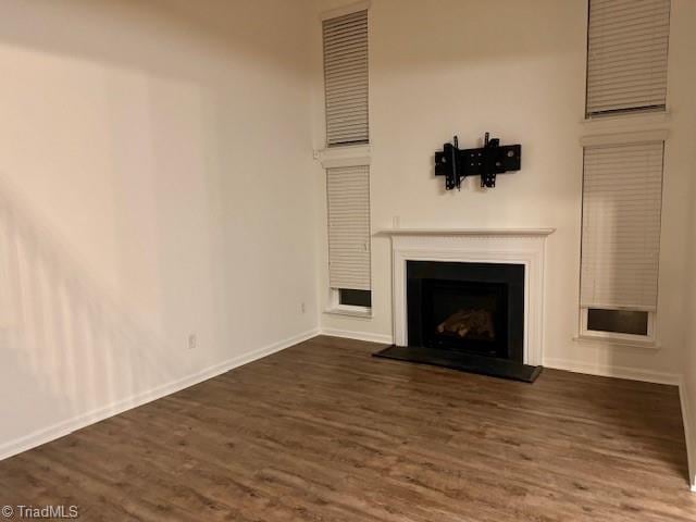 unfurnished living room with dark hardwood / wood-style floors