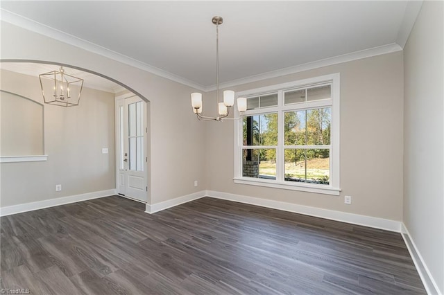 spare room featuring dark hardwood / wood-style flooring, a notable chandelier, and ornamental molding