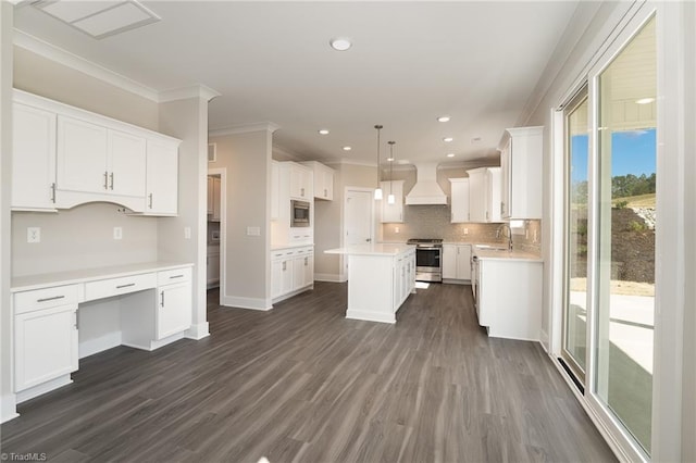 kitchen featuring hanging light fixtures, dark wood-type flooring, stainless steel stove, custom exhaust hood, and a kitchen island