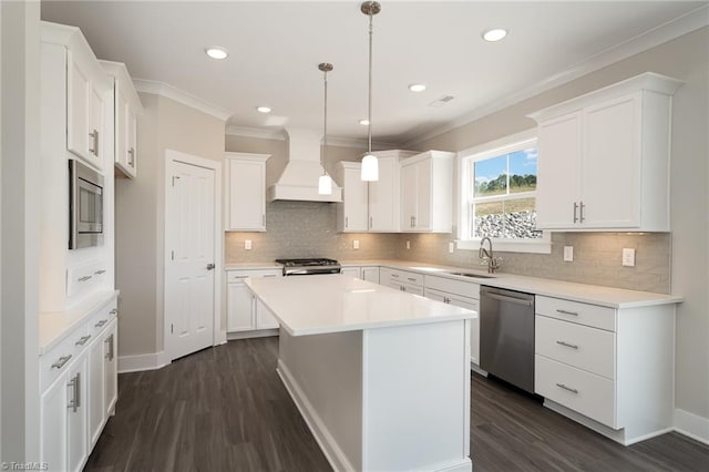 kitchen with premium range hood, a center island, appliances with stainless steel finishes, and white cabinetry