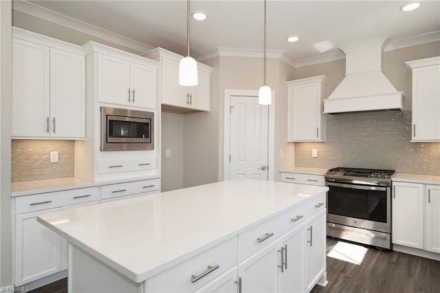 kitchen with appliances with stainless steel finishes, premium range hood, white cabinetry, and dark hardwood / wood-style flooring