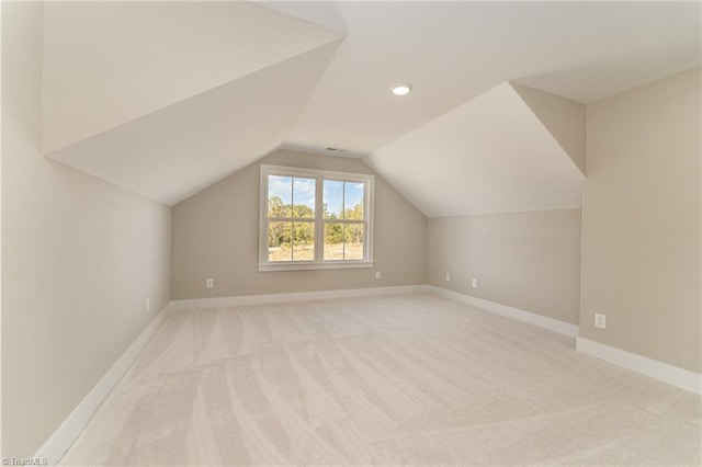 bonus room with light carpet and vaulted ceiling