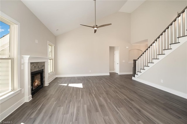 unfurnished living room featuring dark hardwood / wood-style flooring, ceiling fan, and high vaulted ceiling