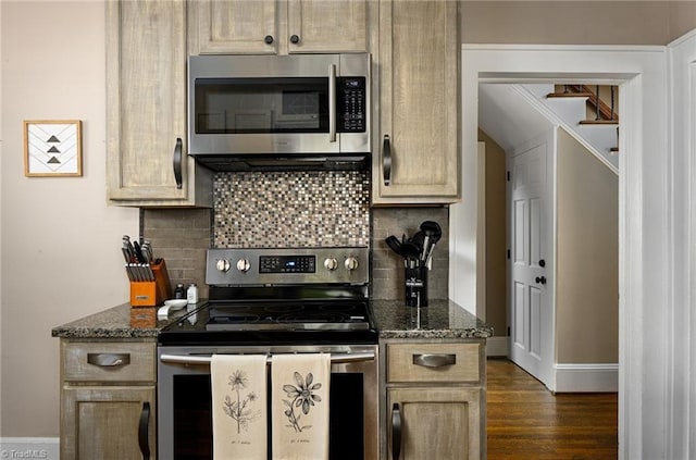 609 W Lexington Ave, High Point, NC 27262 - kitchen with appliances with stainless steel finishes, dark wood finished floors, decorative backsplash, and dark stone counters