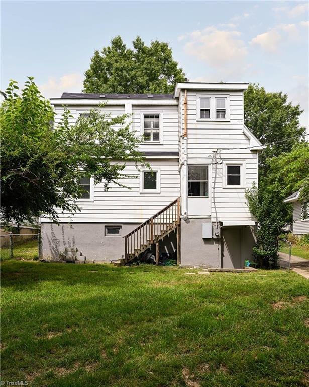 609 W Lexington Ave, High Point, NC 27262 - rear view of property featuring a lawn and stairway