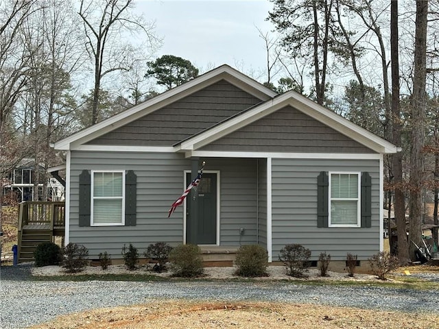 bungalow-style house featuring crawl space and gravel driveway