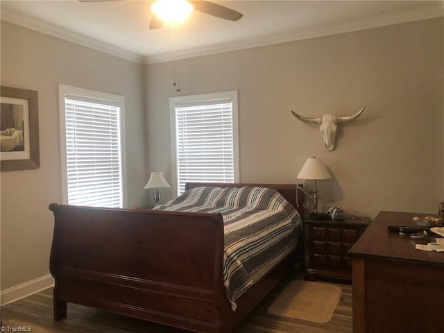 bedroom with multiple windows, crown molding, baseboards, and wood finished floors