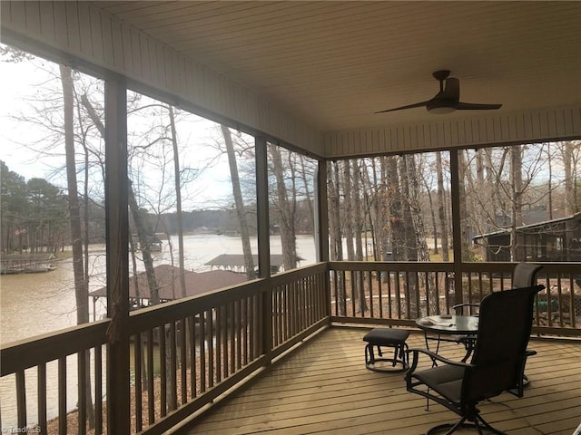 wooden deck with a water view and a ceiling fan