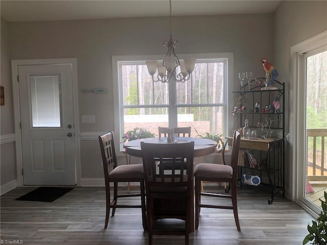 dining space featuring an inviting chandelier, baseboards, and wood finished floors