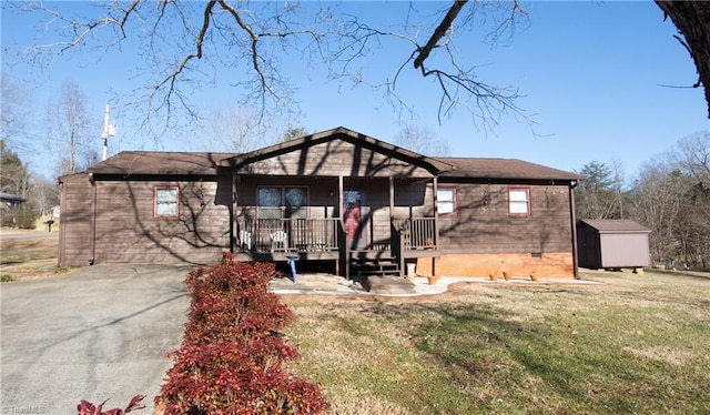 view of front of home featuring a storage shed, a front yard, and a porch