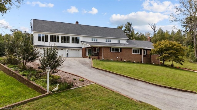 view of property with a garage and a front lawn