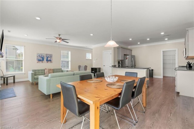 dining space with ceiling fan, ornamental molding, and hardwood / wood-style floors