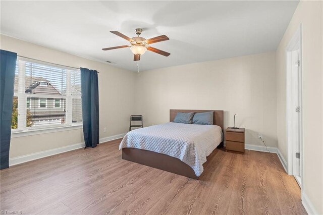 bedroom with light hardwood / wood-style floors and ceiling fan