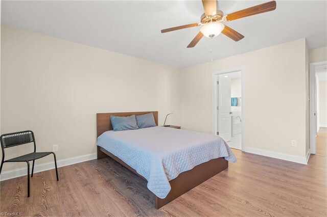 bedroom with ensuite bathroom, hardwood / wood-style flooring, and ceiling fan