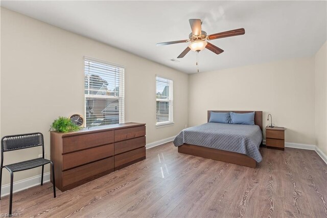 bedroom with light hardwood / wood-style flooring and ceiling fan