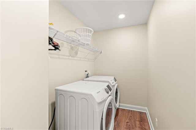 laundry room with washer and dryer and hardwood / wood-style flooring