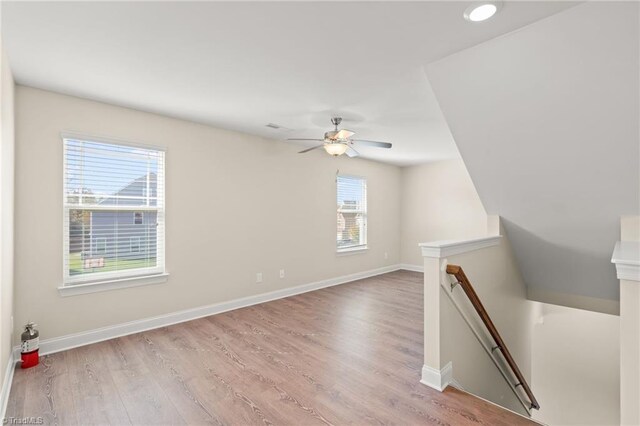 empty room featuring light hardwood / wood-style flooring, a healthy amount of sunlight, and ceiling fan