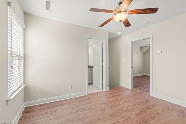 unfurnished bedroom with ensuite bath, a closet, light wood-type flooring, and ceiling fan