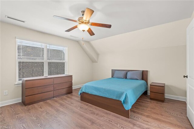 bedroom featuring ceiling fan, lofted ceiling, and light hardwood / wood-style flooring