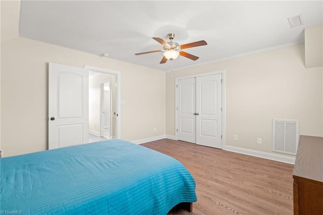 bedroom with wood-type flooring, a closet, and ceiling fan