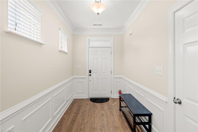 entryway with ornamental molding and wood-type flooring