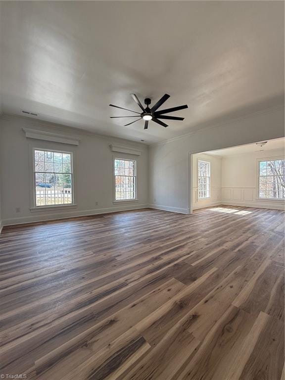 unfurnished living room featuring dark wood-type flooring, baseboards, and a ceiling fan