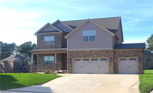 craftsman-style house with board and batten siding, a front lawn, brick siding, an attached garage, and driveway
