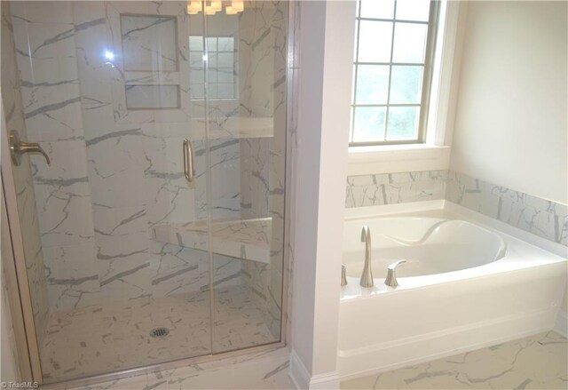 bathroom featuring a bath, marble finish floor, and a marble finish shower