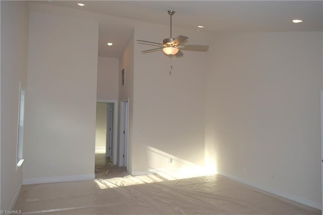 empty room featuring a high ceiling, baseboards, a ceiling fan, and recessed lighting