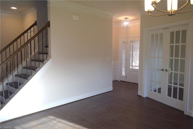 interior space featuring a chandelier, baseboards, crown molding, and wood finished floors