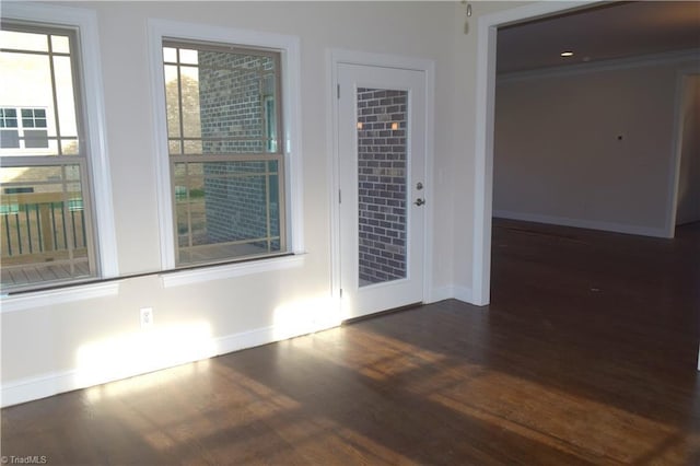 unfurnished room featuring wood finished floors, baseboards, and ornamental molding